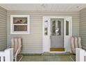 Close up of the front porch with seating and decorative details, creating a charming and inviting entrance to the home at 1306 De La Garza Pl, The Villages, FL 32162