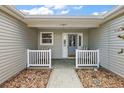 Inviting front porch featuring a seating area with white railing that offers a cozy spot to enjoy the outdoors at 1306 De La Garza Pl, The Villages, FL 32162