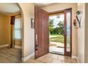 Open door reveals a tiled entryway with a keyless door lock and views to the backyard at 15921 Hanson View Dr, Tavares, FL 32778