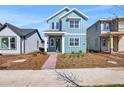 Inviting two-story home with a manicured lawn, bright blue siding, white trim, and a brick walkway at 3106 Voyager Ave, St Cloud, FL 34771