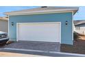 Spacious two-car garage with a white door, modern lighting fixtures, and paved driveway, ideal for parking at 3106 Voyager Ave, St Cloud, FL 34771