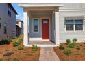 Inviting front porch featuring brick pavers, white columns, and a vibrant red front door at 6521 Daypack Ln, St Cloud, FL 34771
