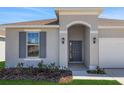 Close-up of the home's front entrance shows an arched entryway and sleek gray door at 191 Bottle Brush Dr, Haines City, FL 33844