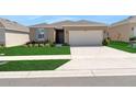 Charming single-story home with a well-manicured lawn and attached two-car garage at 207 Bottle Brush Dr, Haines City, FL 33844