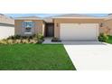 Charming single-story home with a well-manicured lawn and attached two-car garage at 207 Bottle Brush Dr, Haines City, FL 33844