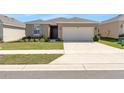 Charming single-story home with a well-manicured lawn and attached two-car garage at 207 Bottle Brush Dr, Haines City, FL 33844