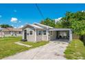 Cozy home featuring a well-kept lawn, a convenient carport, and light grey siding at 622 N Disston Ave, Tavares, FL 32778