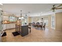 Open kitchen and dining area with granite island, tile flooring, and natural light at 557 Dowling Cir, Lady Lake, FL 32159