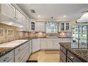Bright kitchen with granite countertops, white cabinets, and stainless steel appliances at 557 Dowling Cir, Lady Lake, FL 32159