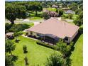 Aerial view of a home featuring a screened-in patio and a well-maintained lawn surrounded by mature trees at 39705 Grove Hts, Lady Lake, FL 32159