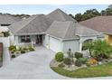 Attractive single-Gathering home with a well-manicured lawn, gray roof, and a spacious driveway leading to a garage at 2968 Wotring Way, The Villages, FL 32163