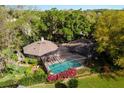 House with pool and screened enclosure; surrounded by lush trees at 1785 Maine Ct, Tavares, FL 32778