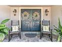Charming front porch with rocking chairs and elegant double doors at 1785 Maine Ct, Tavares, FL 32778