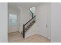 Modern staircase with black metal railings and light wood floors at 17036 Clear Mind Aly, Winter Garden, FL 34787