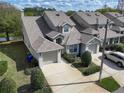 An angled exterior shot of a townhouse complex, showcasing the garages and landscaping at 115 Lake Emma Cove Dr # 1, Lake Mary, FL 32746