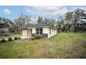 Expansive lawn wraps this newly renovated home with neutral tones and a modern aesthetic at 2482 County Road 423, Lake Panasoffkee, FL 33538