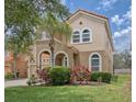 Charming two-story home featuring a clay tile roof, arched entry, and well-maintained landscaping at 436 Orange Cosmos Blvd, Davenport, FL 33837