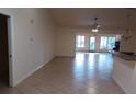 Open living room with tile flooring, neutral walls and a ceiling fan for efficient cooling at 8590 Se 157Th Pl, Summerfield, FL 34491