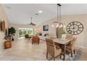 Bright dining room features a wood table and wicker chairs, adjacent to the living room at 410 Ainsworth Cir, The Villages, FL 32162