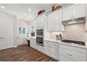 Modern kitchen with white cabinets, stainless steel appliances, and hardwood floors at 8732 Providence Ct, Mount Dora, FL 32757