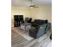 Gathering room with a large TV, gaming setup, and two black leather sofas at 3726 Imperial Dr, Winter Haven, FL 33880