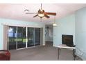 Spacious living room featuring sliding glass doors and a ceiling fan at 651 Timbercrest Dr, Leesburg, FL 34748