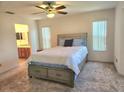 Comfortable bedroom with neutral carpet, ceiling fan, and ensuite bathroom at 651 Timbercrest Dr, Leesburg, FL 34748