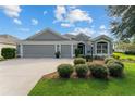 Gray house with 3-car garage and lush landscaping at 768 Bradford Loop, The Villages, FL 32163