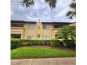 Exterior view of a condo building with landscaping and a grassy lawn at 6116 Curry Ford Rd # 229, Orlando, FL 32822