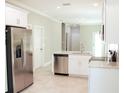 Modern kitchen with stainless steel appliances, white cabinetry and countertops, and tile flooring at 2114 Waitman, Leesburg, FL 34748