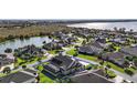 Aerial view of a house with a private screened-in pool, lake view, and solar panels at 4049 Nostalgia Ter, The Villages, FL 32163