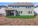 View of the back of the home with a covered patio and green lawn with freshly laid straw at 6208 Trailblaze Bnd, St Cloud, FL 34771