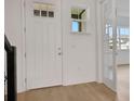 Bright foyer with light hardwood floors, a white door, and glass French doors leading to another room at 6608 Quest St, Saint Cloud, FL 34771