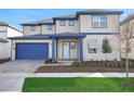 Charming two-story home featuring a blue garage door and trim and a manicured front lawn at 6612 Quest St, St Cloud, FL 34771