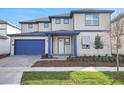 Charming two-story home featuring a blue garage door and trim and a manicured front lawn at 6612 Quest St, St Cloud, FL 34771