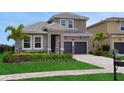 Elegant two-story home with lush lawn, paver driveway, and a two-car garage at 15615 Vetta Dr, Montverde, FL 34756