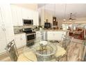 Modern kitchen with white cabinets, stainless steel appliances, and an island at 3109 Timucua Cir, Orlando, FL 32837