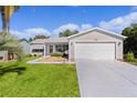 Charming single-story home with well-manicured lawn, gray siding, and a two-car garage at 803 Camino Del Rey Dr, The Villages, FL 32159