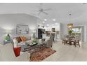 Bright, open living room with tile floors, ceiling fan, and neutral decor, leading to the kitchen and dining area at 8194 Se 177Th Winterthur Loop, The Villages, FL 32162