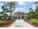 Elegant two-story home featuring a paver driveway, well-maintained landscaping, and attached three-car garage at 16909 Crete Way, Bella Collina, FL 34756