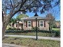 Charming home with manicured lawn, mature trees and lush landscaping with a view of a streetlight at 210 Westcott Ct, Deland, FL 32724
