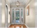 Inviting foyer featuring a decorative glass door, hardwood floors, and elegant lighting at 210 Westcott Ct, Deland, FL 32724