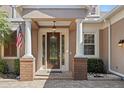 Elegant front entrance with decorative glass door, stately columns and brick accents at 210 Westcott Ct, Deland, FL 32724