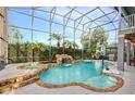Inviting screened-in pool with waterfall feature, adjacent spa, and ample deck space for entertaining at 13412 Fox Glove St, Winter Garden, FL 34787