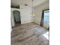 This dining area showcases updated flooring, a modern chandelier, and natural light from a nearby window at 24124 Robinwood St, Leesburg, FL 34748
