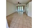 Bright living room featuring tile flooring, ceiling fan, and sliding glass doors to the outdoor space at 24124 Robinwood St, Leesburg, FL 34748
