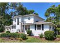 Two-story home with a manicured lawn and mature landscaping at 1405 Hilltop Dr, Mount Dora, FL 32757