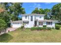 Inviting two-story home with lush landscaping and a brick driveway at 1405 Hilltop Dr, Mount Dora, FL 32757