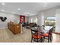 Open-concept living area with tile flooring, granite countertops, and access to a screened-in patio at 4847 Clock Tower Dr, Kissimmee, FL 34746