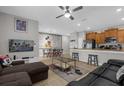 Open-concept living room featuring tile floors, ceiling fan, eat-in kitchen, and fun Mickey Mouse decor at 4847 Clock Tower Dr, Kissimmee, FL 34746